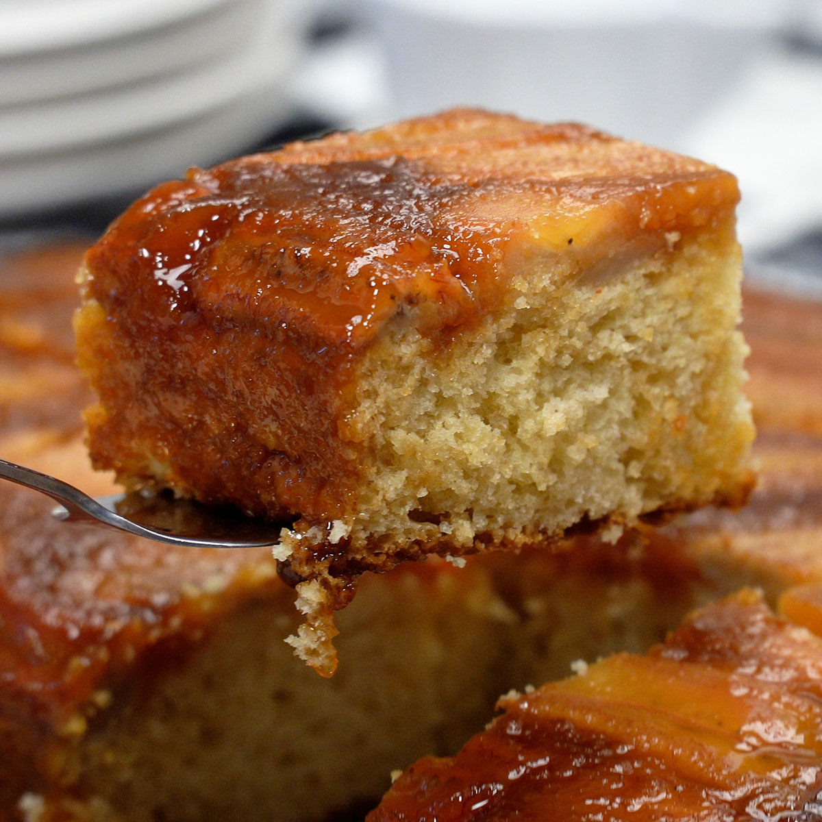 Fatia de torta de banana caseira com caramelo sendo servida.
