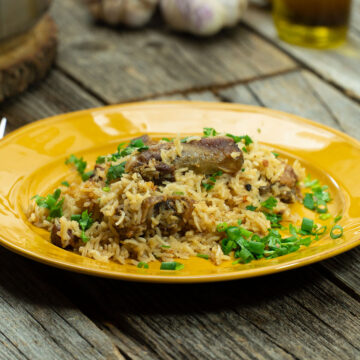 Empratamento arroz com suã de porco finalizado com ervas frescas.
