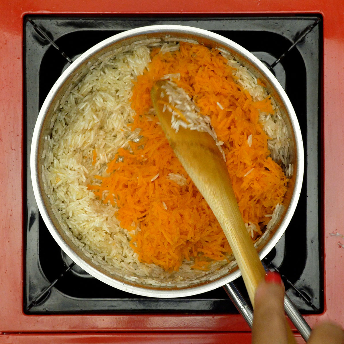 Cebola e alho refogando para preparo do arroz de cenoura.
