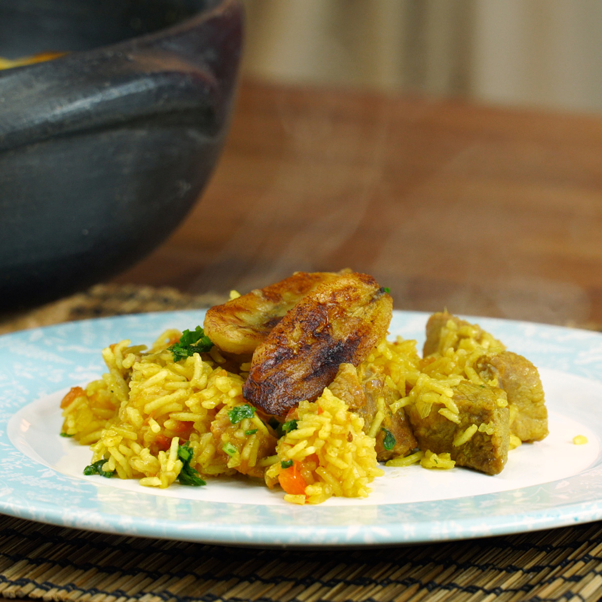 Fatias de banana frita distribuídas sobre o arroz de porco pronto para servir.