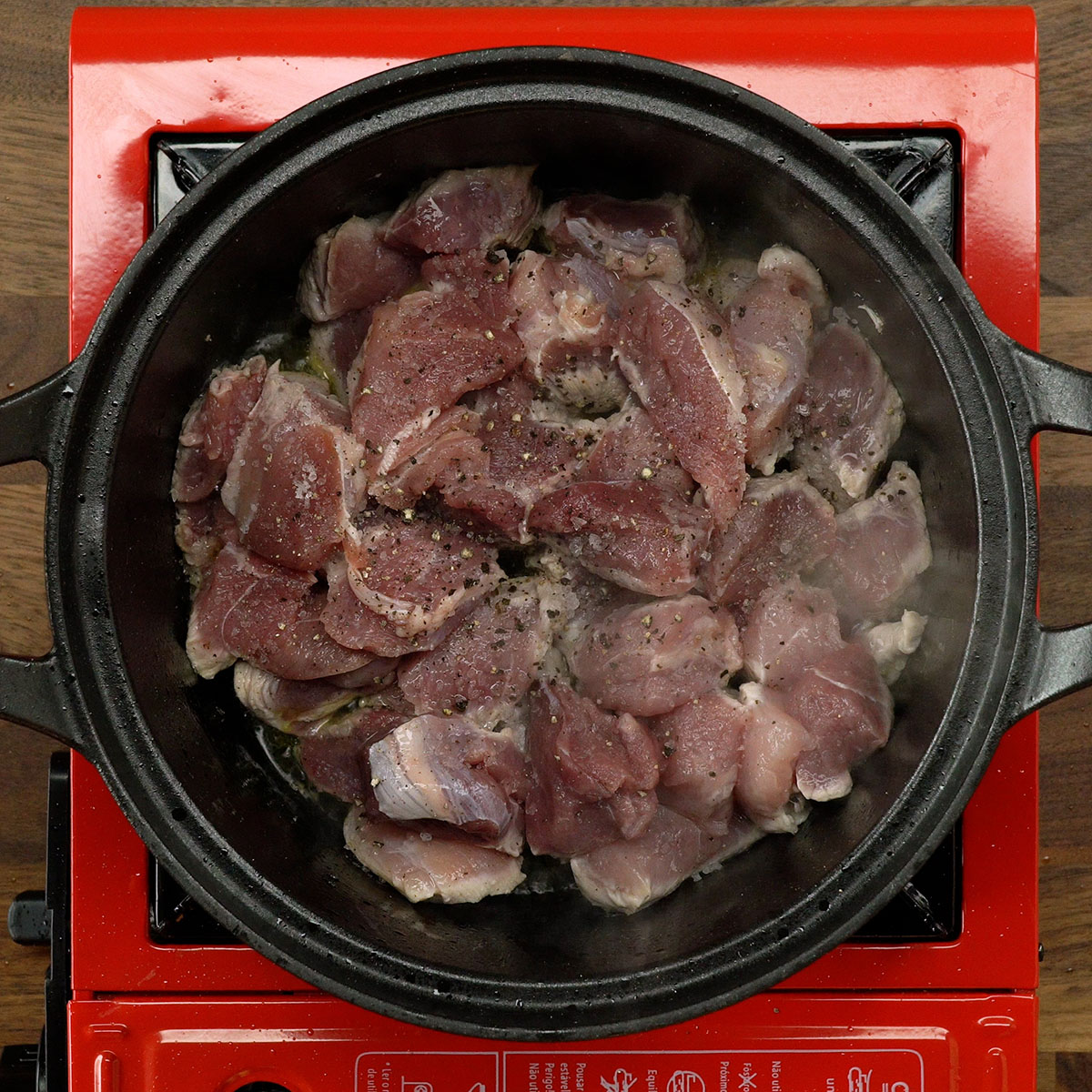 Cubos de carne de porco temperados com sal e pimenta.