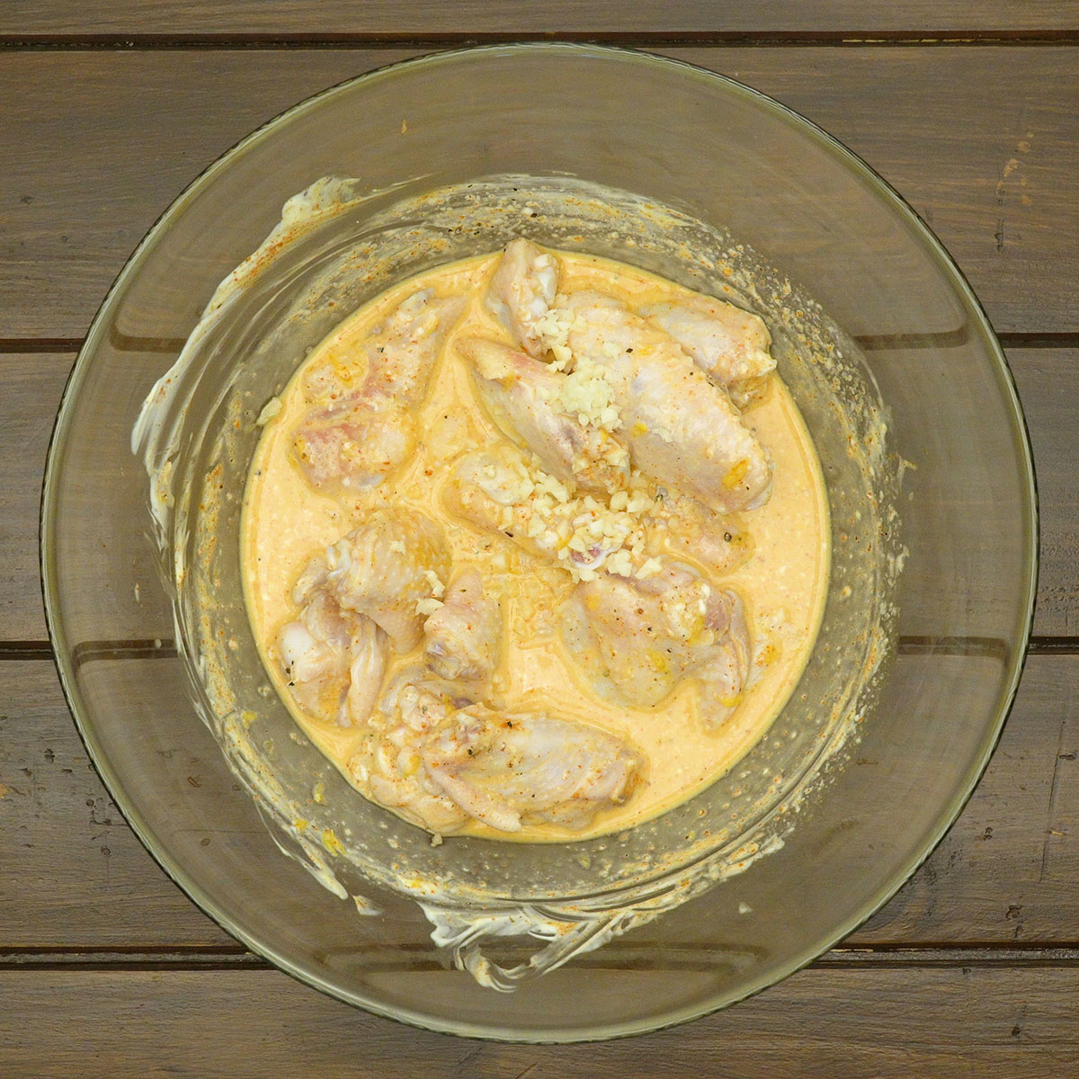 Asinhas de frango marinando com suco de laranja e alho.