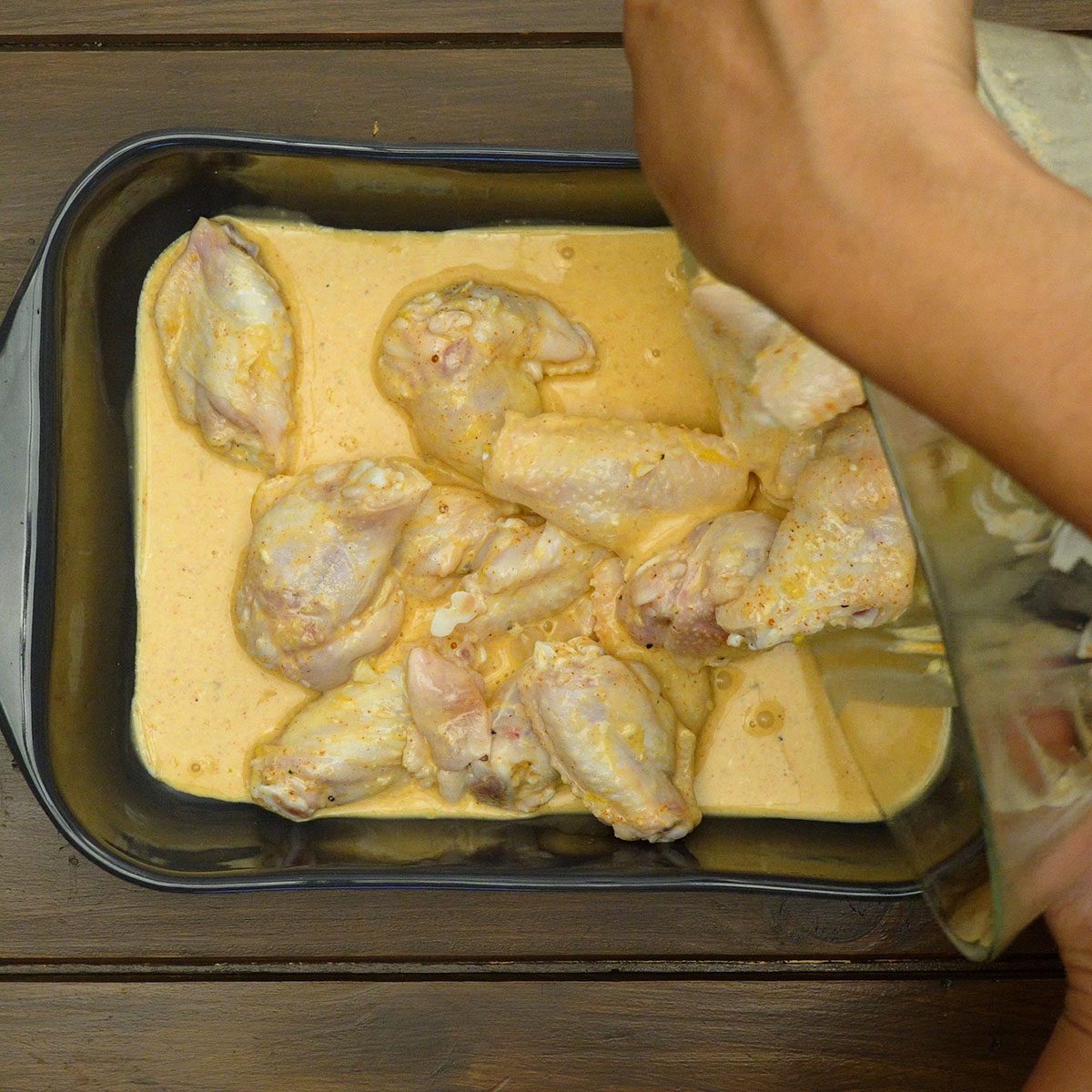 Asinhas de frango com marinada de laranja acomodadas em assadeira.