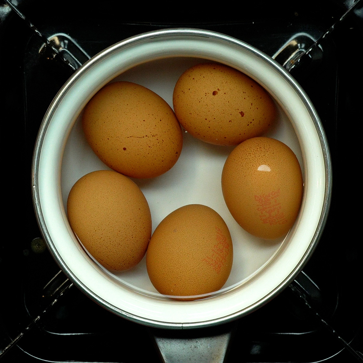Ovos cozidos sendo resfriados em água gelada após o cozimento.