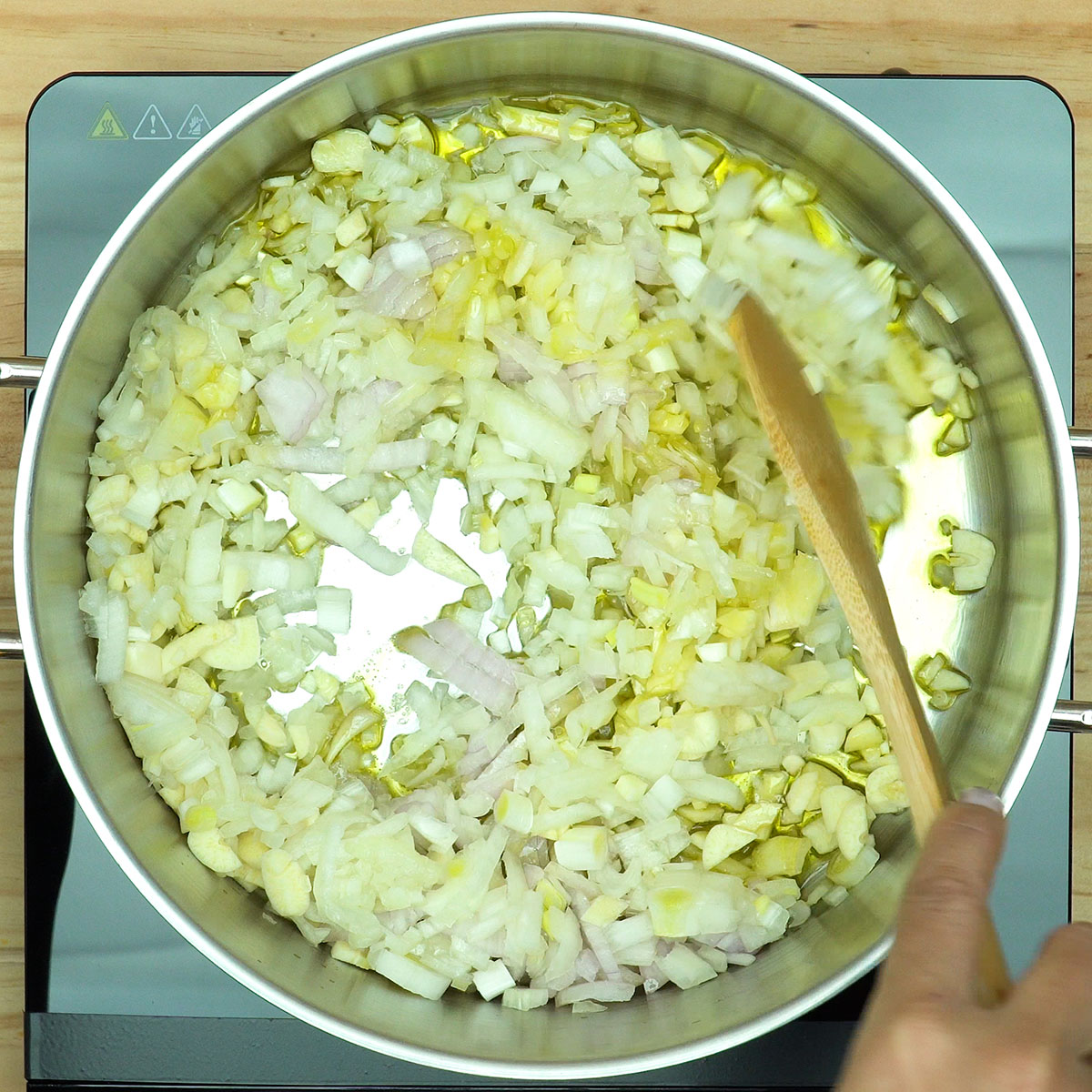 Cebola e alho refogando no azeite para preparo de bacalhau com natas.