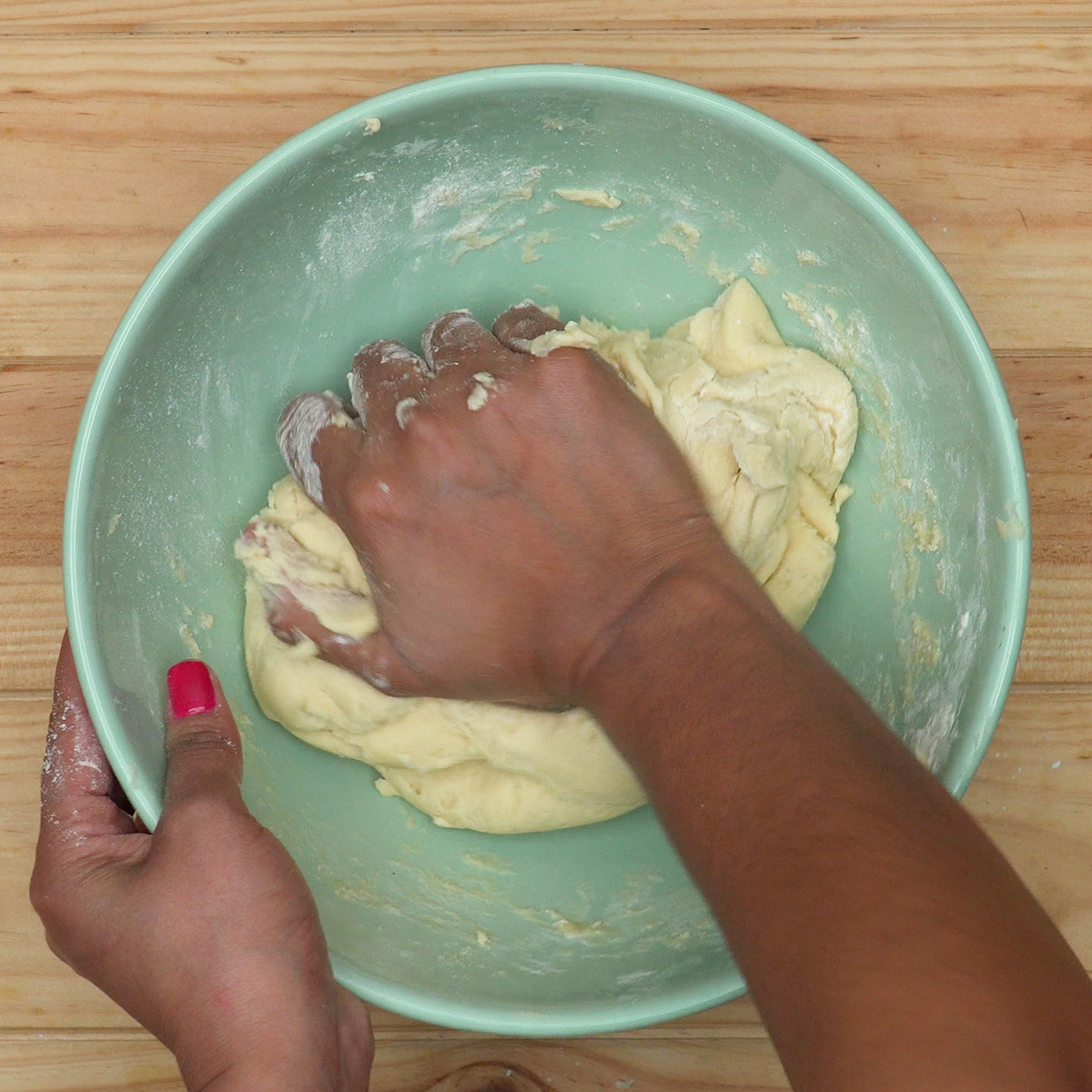 Massa de biscoitos de nata sendo trabalhada com as mãos.