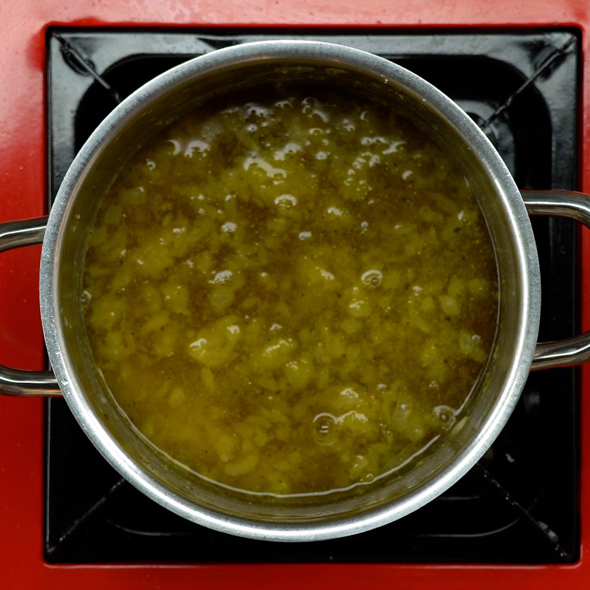 Mostarda e caldo de legumes sendo incorporados ao molho na panela.