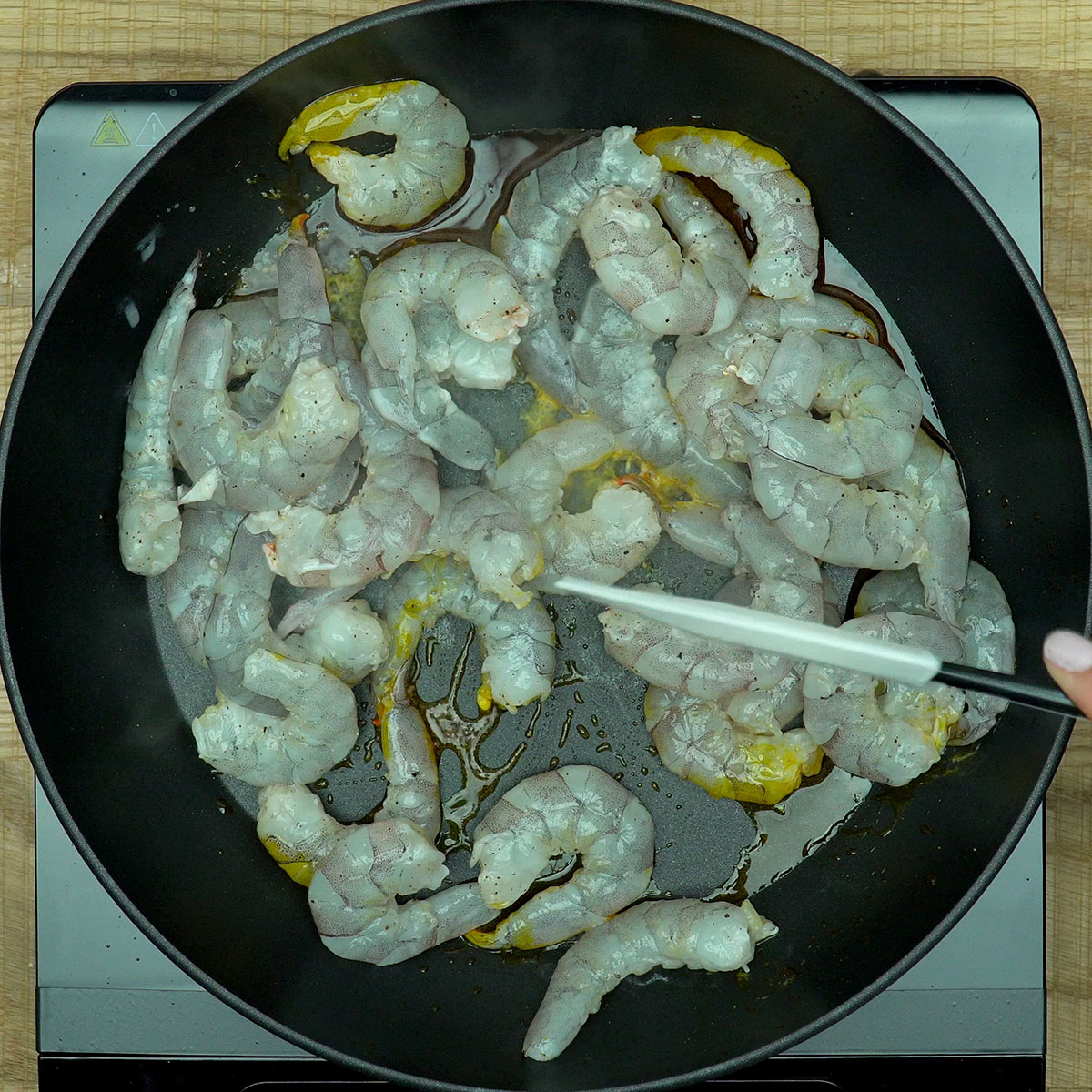 Camarões sendo cozinhados rapidamente no azeite de dendê.