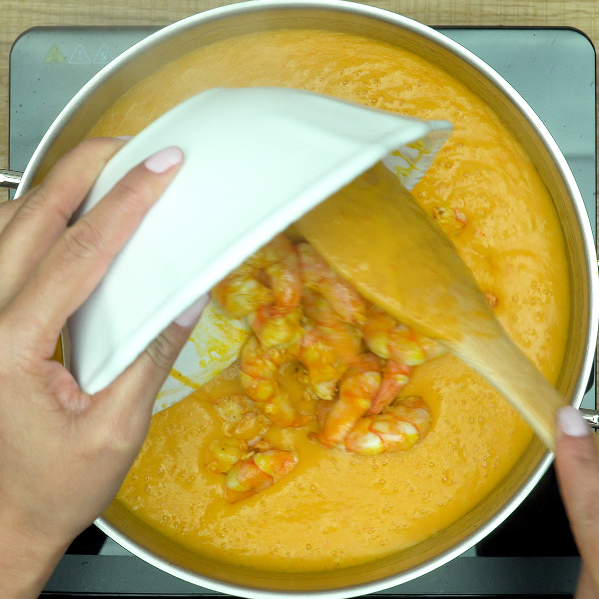 Creme de mandioca misturado ao molho e aos camarões.