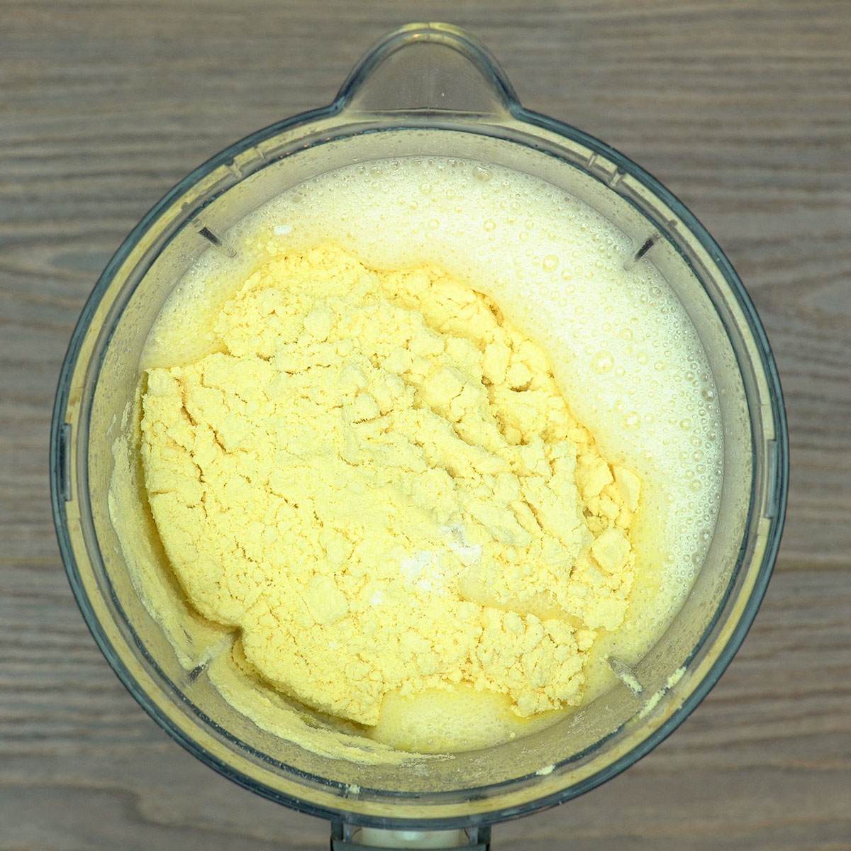 Massa do bolo de fubá com goiabada ficando lisa após adicionar farinha e fubá.