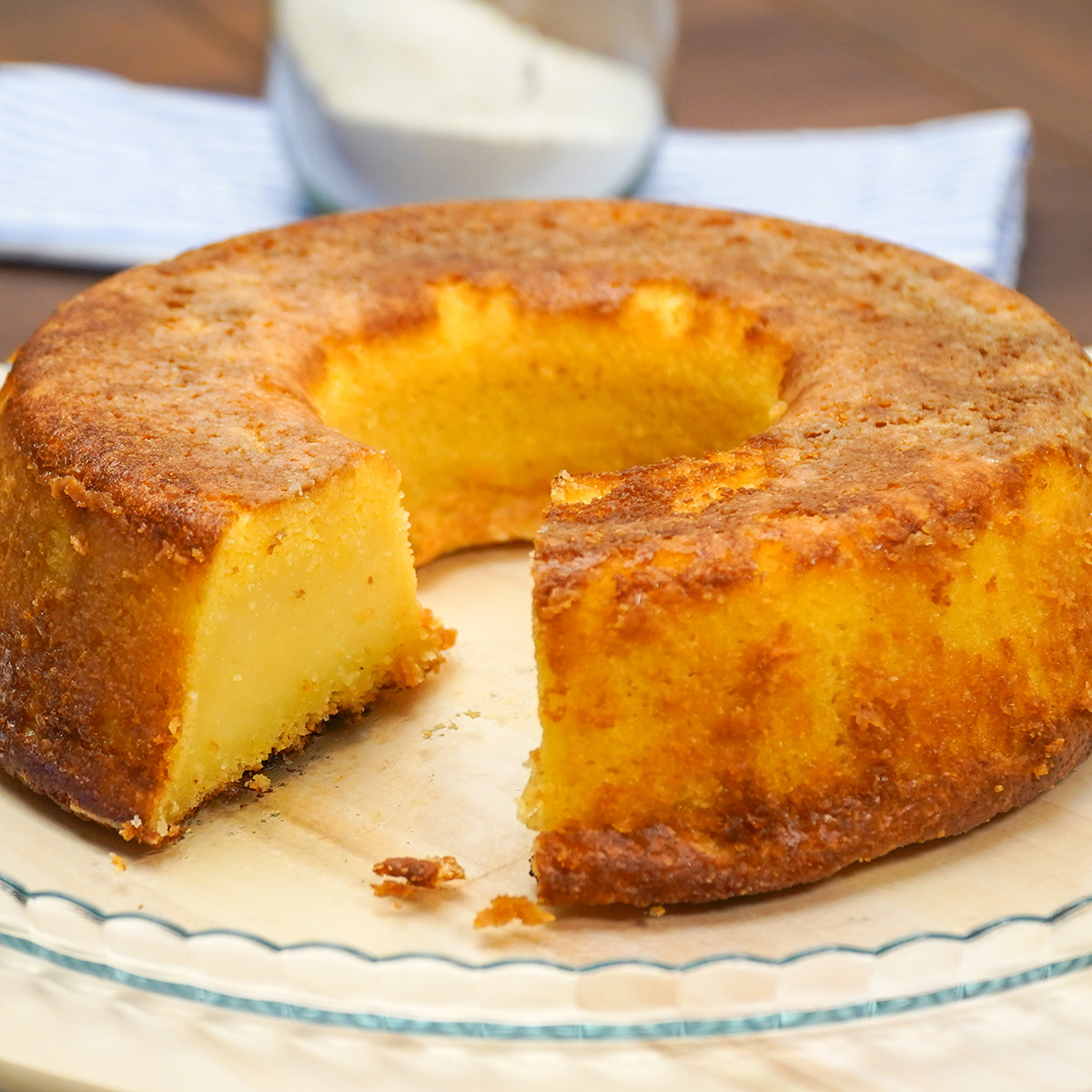 Bolo de fubá cremoso desenformado aberto sendo servido.