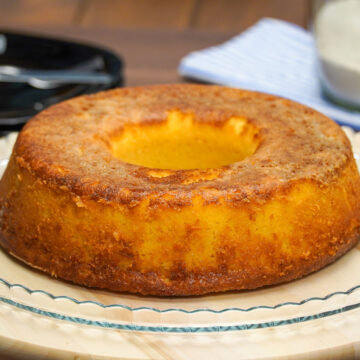 Bolo de fubá cremoso desenformado com textura cremosa e superfície dourada.