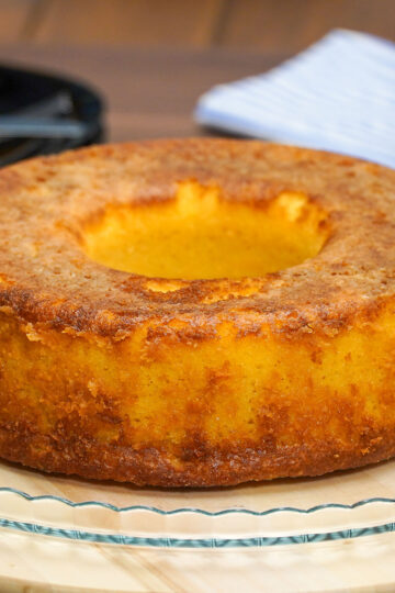 Bolo de fubá cremoso desenformado com textura cremosa e superfície dourada.