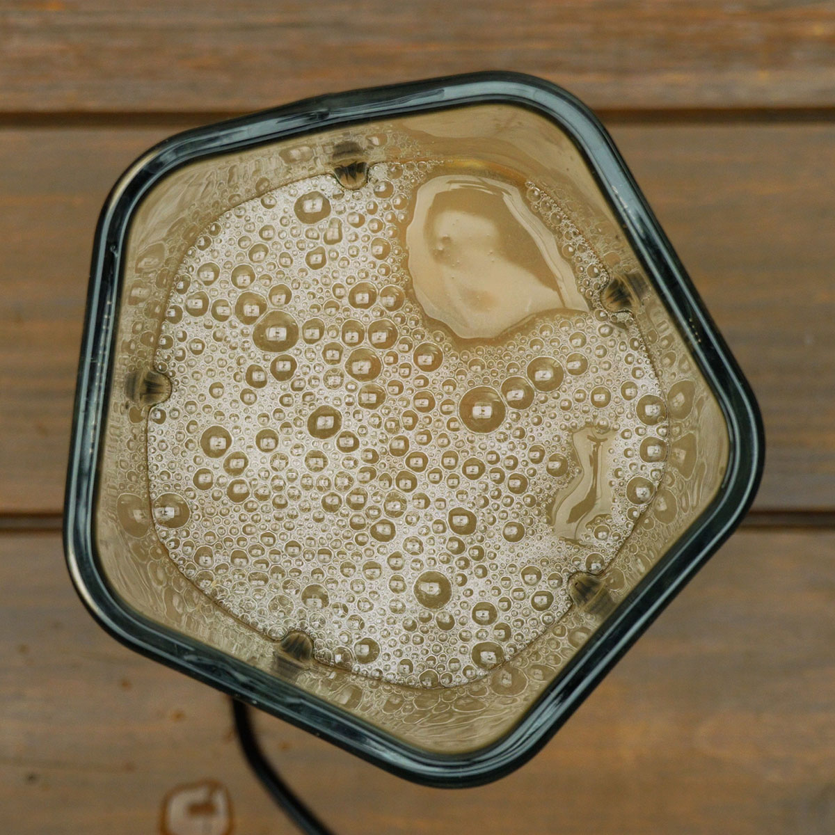 Feijão cozido sendo batido no liquidificador para formar um caldo cremoso.