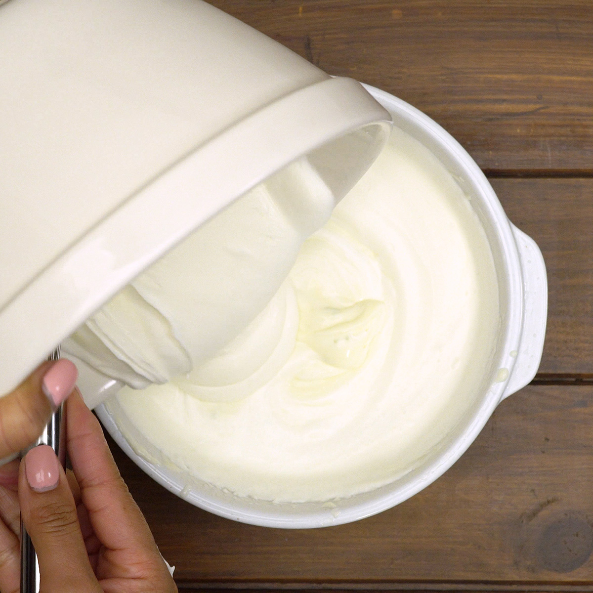 Chantilly sendo incorporado ao creme de limão com espátula.