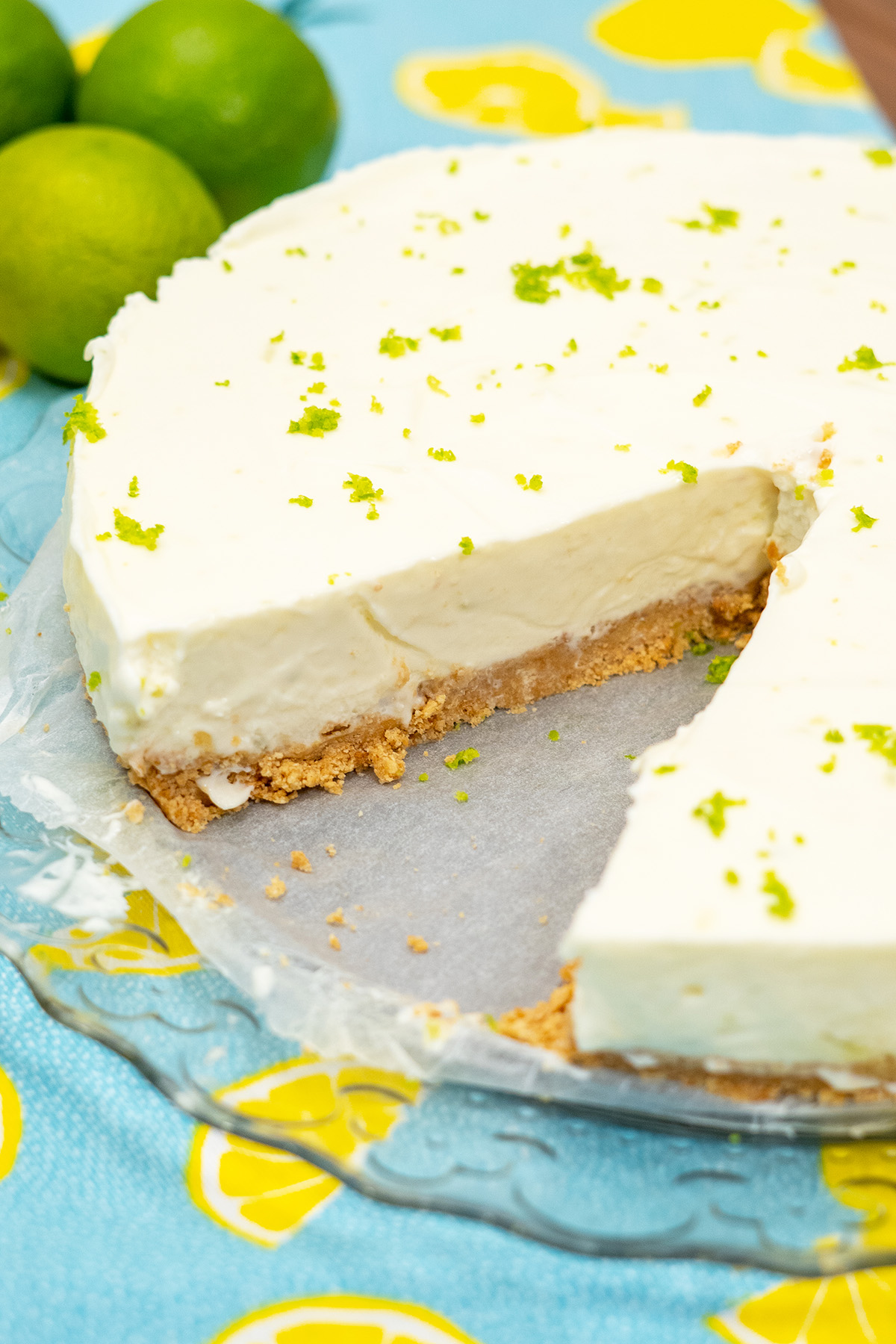 Cheesecake de limão pronto finalizado com raspas de limão servindo em fatias.