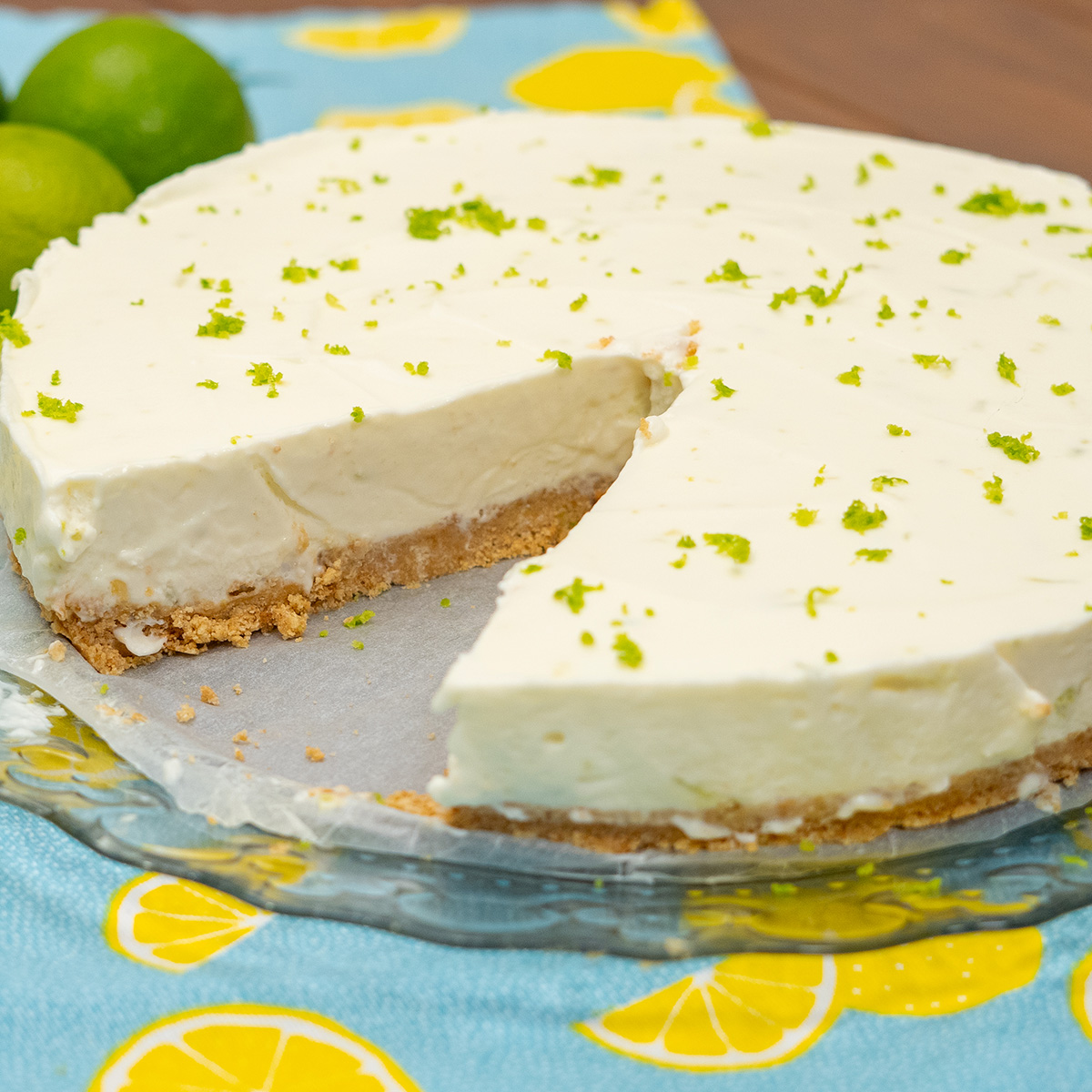 Cheesecake de limão pronto finalizado com raspas de limão servindo em fatias.