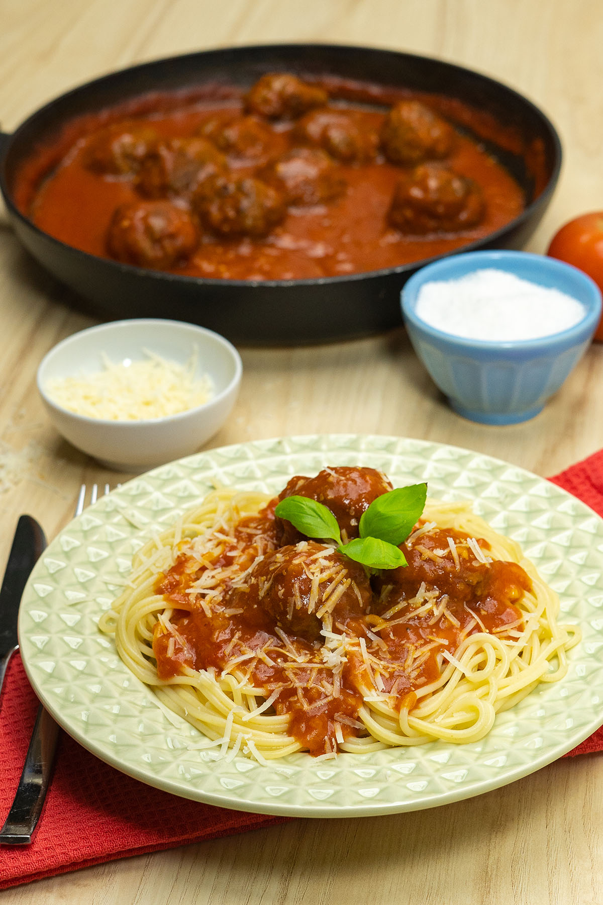 Empratamento almôndegas com sopa de cebola servidas com parmesão e manjericão fresco como decoração.