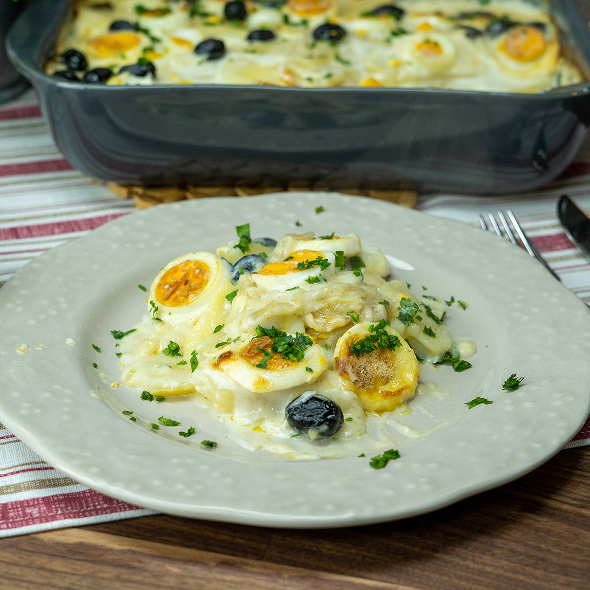Empratamento bacalhau com molho branco finalizado com salsa a gosto.