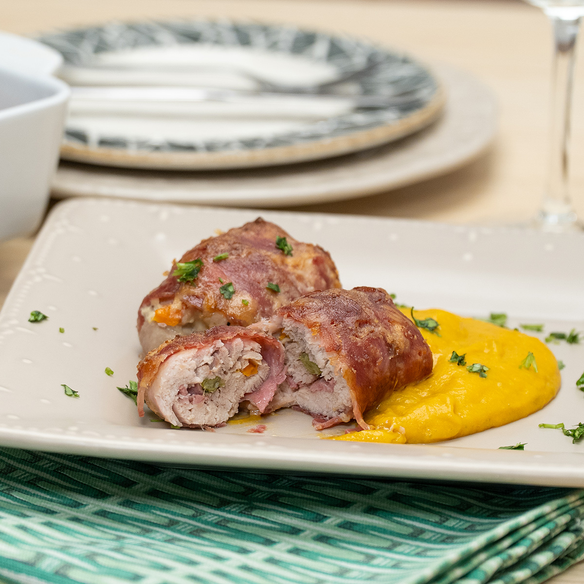 Empratamento enroladinhos de frango com legumes finalizado com salsa.