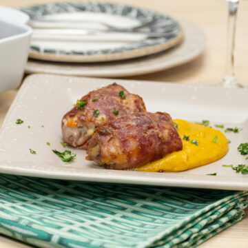 Empratamento enroladinhos de frango com legumes finalizado com salsa.