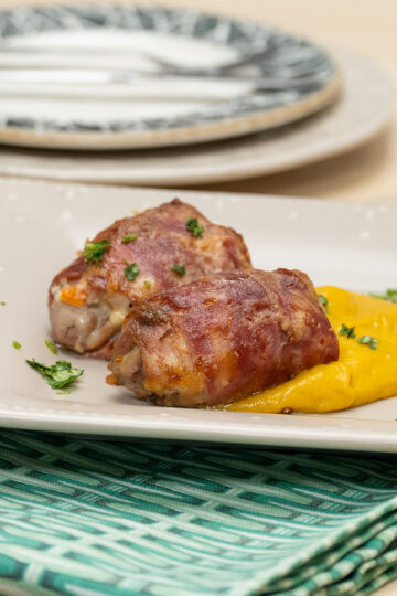 Empratamento enroladinhos de frango com legumes finalizado com salsa.