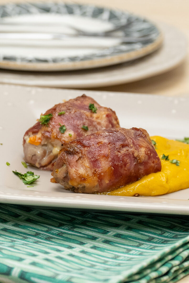 Empratamento enroladinhos de frango com legumes finalizado com salsa.