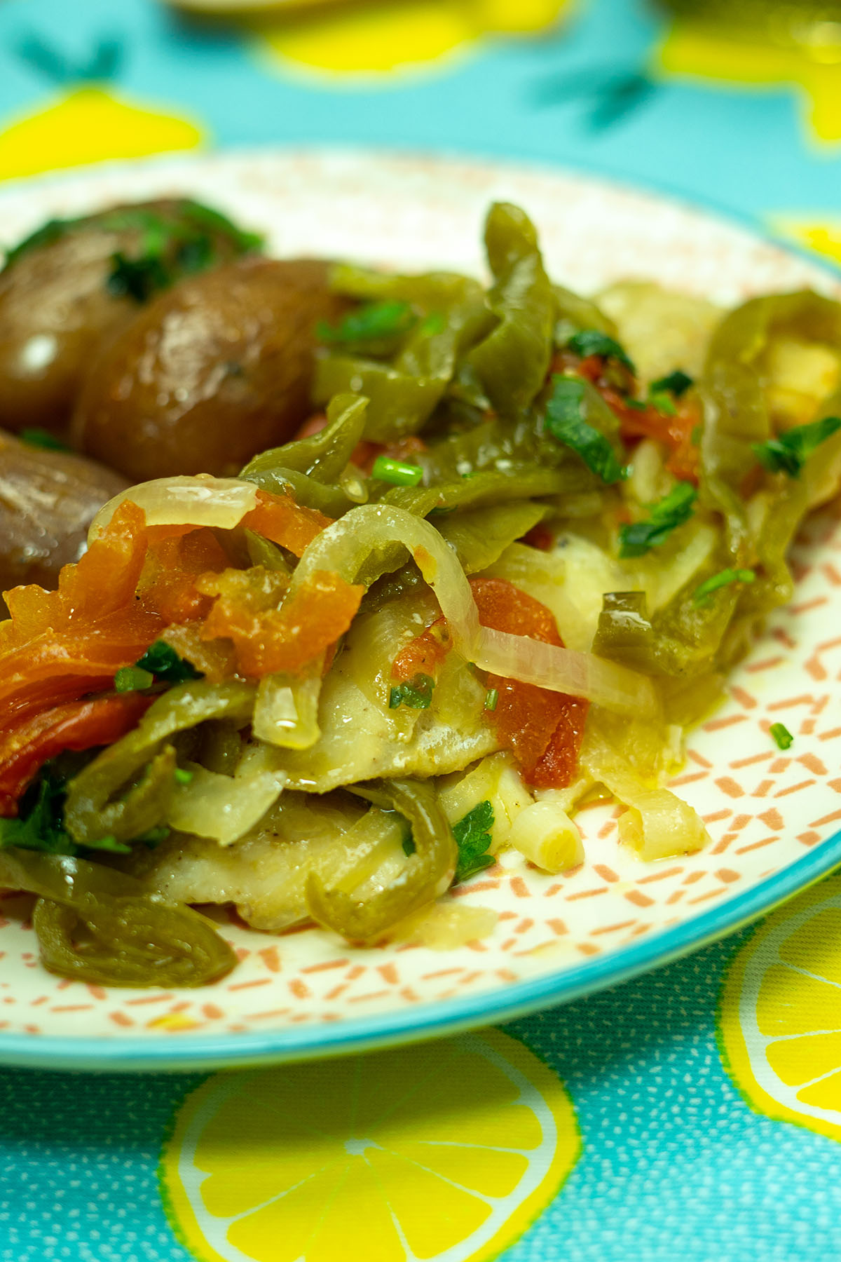 Empratamento filetes de peixe no forno com batatas e legumes assados.