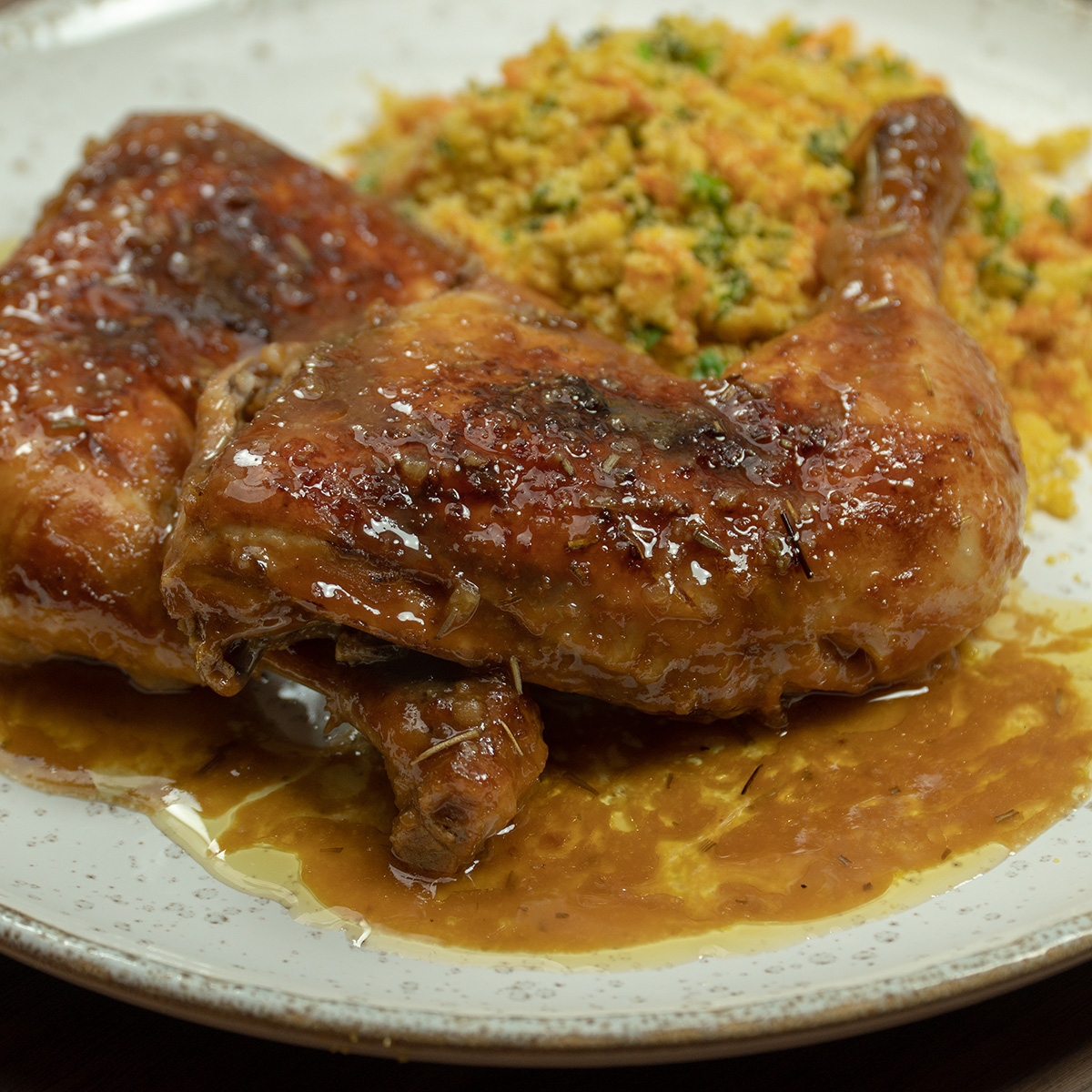 Empratamento frango com cerveja assado na travessa pronto com farofa de acompanhamento.