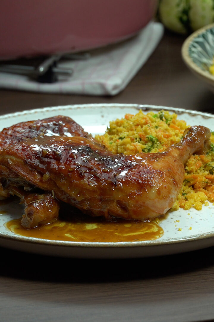 Empratamento frango com cerveja assado na travessa pronto com farofa de acompanhamento.