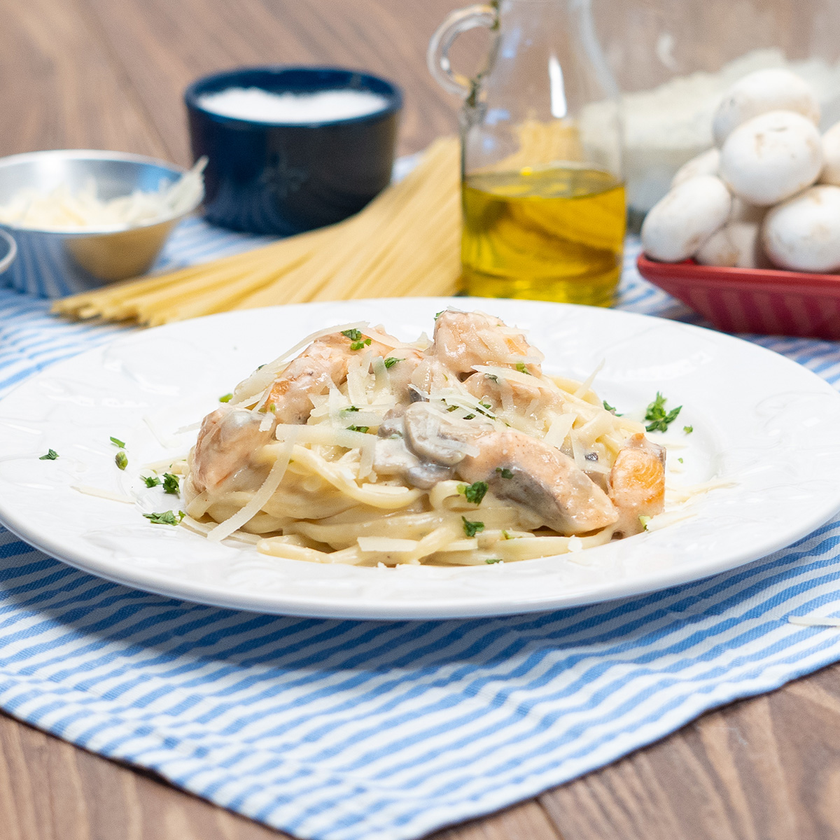 Empratamento linguine com salmão e cogumelo finalizado com queijo parmesão ralado.