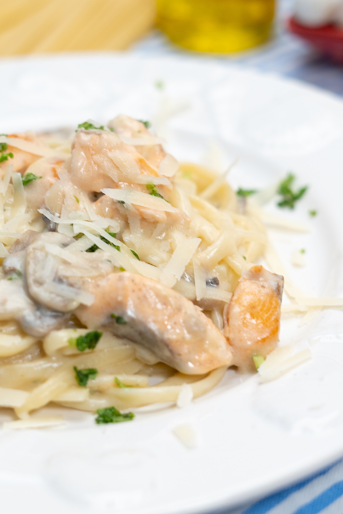 Empratamento linguine com salmão e cogumelo finalizado com queijo parmesão ralado.