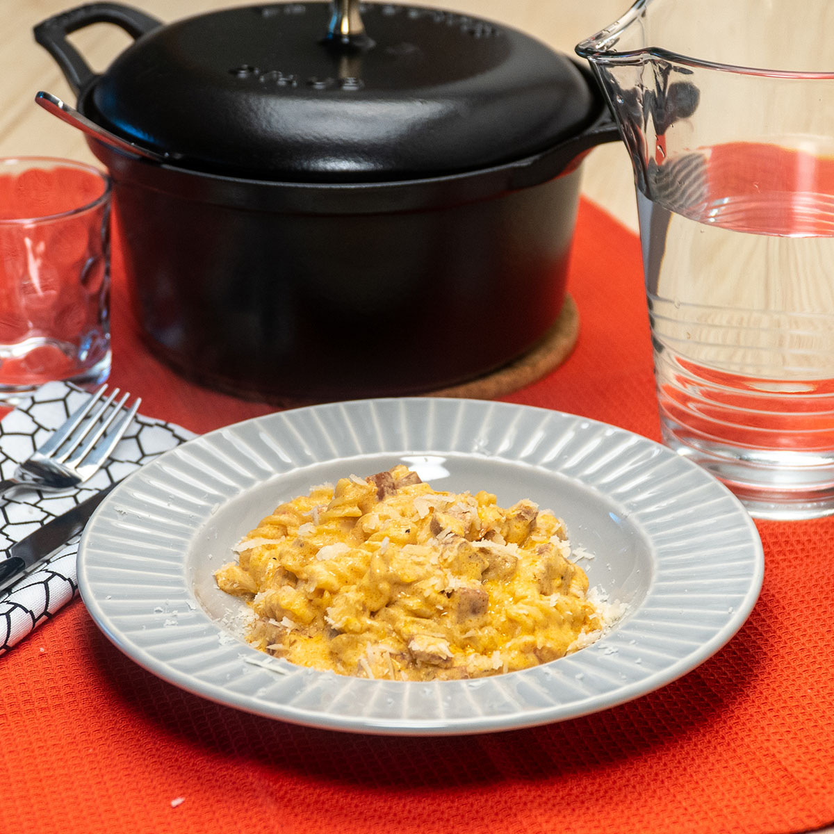 Empratamento macarrão cremoso com linguiça calabresa finalizada com queijo parmesão ralado por cima.