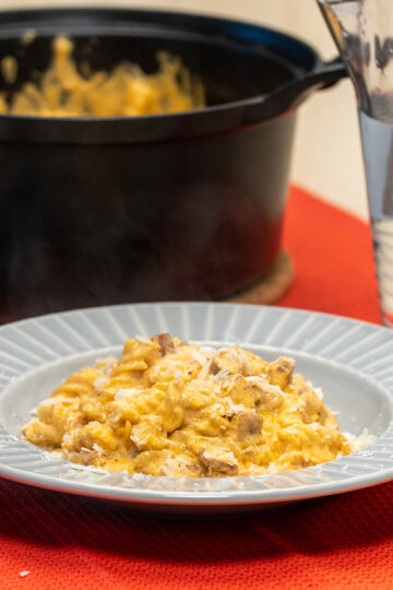 Empratamento macarrão cremoso com linguiça calabresa finalizada com queijo parmesão ralado por cima.