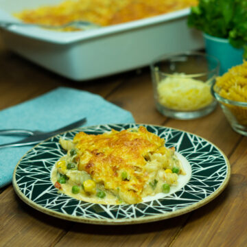 Empratamento macarrão gratinado com frango servido.