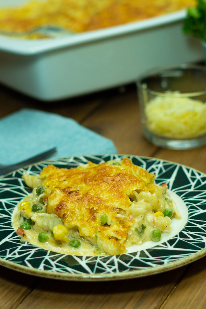 Empratamento macarrão gratinado com frango servido.