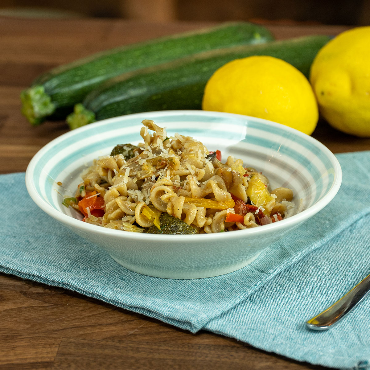 Empratamento macarrão integral com legumes assados finalizado com salsa picada e parmesão ralado.
