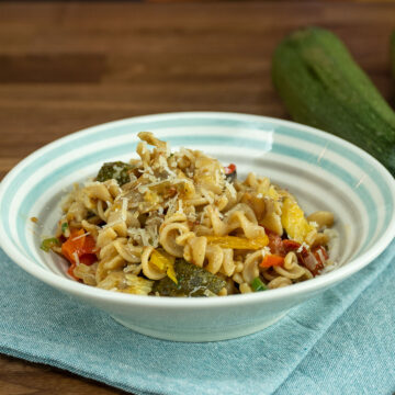 Empratamento macarrão integral com legumes assados finalizado com salsa picada e parmesão ralado.