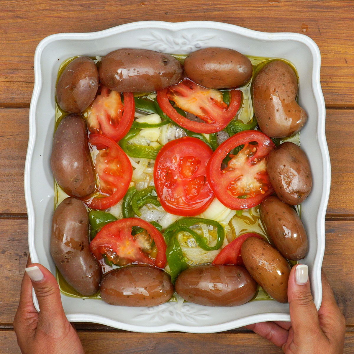 Travessa com peixe e legumes assando no forno.