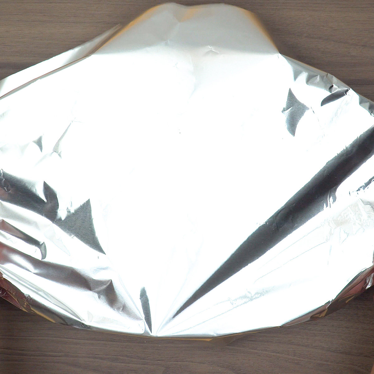 Travessa de frango coberta com papel-alumínio pronta para assar