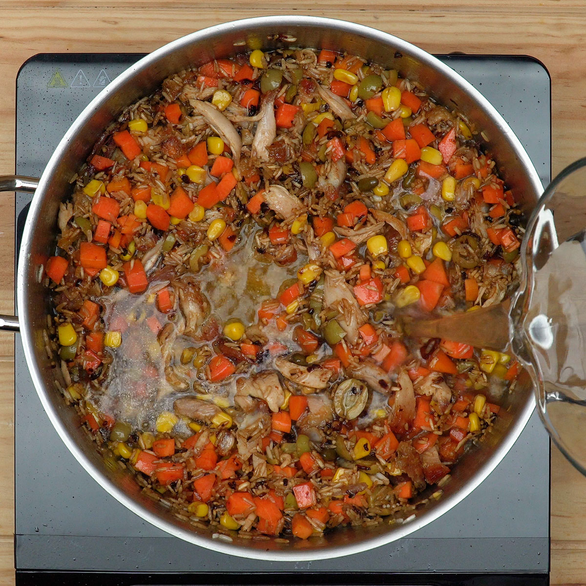 Água quente adicionada ao arroz e frango da galinhada.
