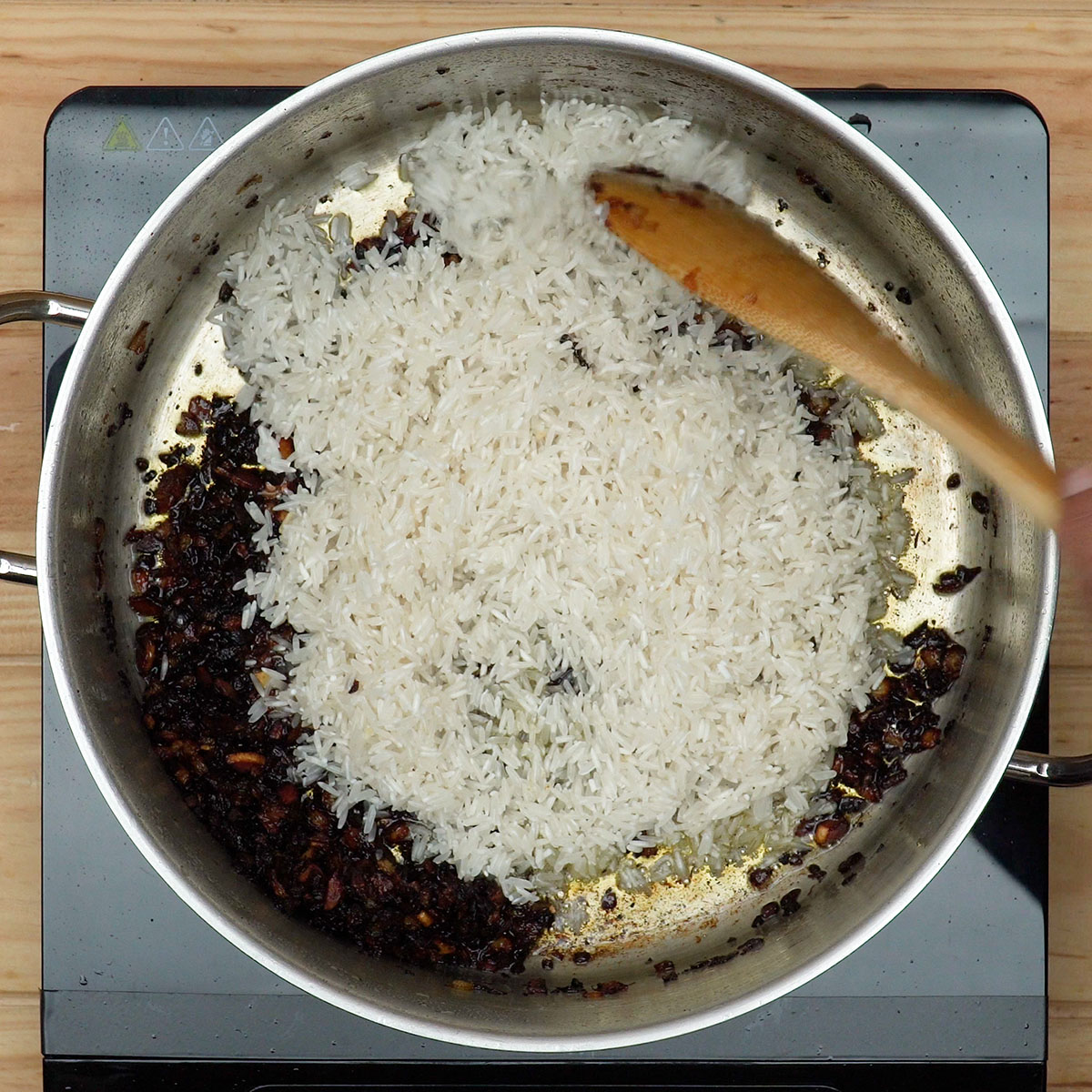 Arroz sendo tostado para preparar galinhada tradicional.