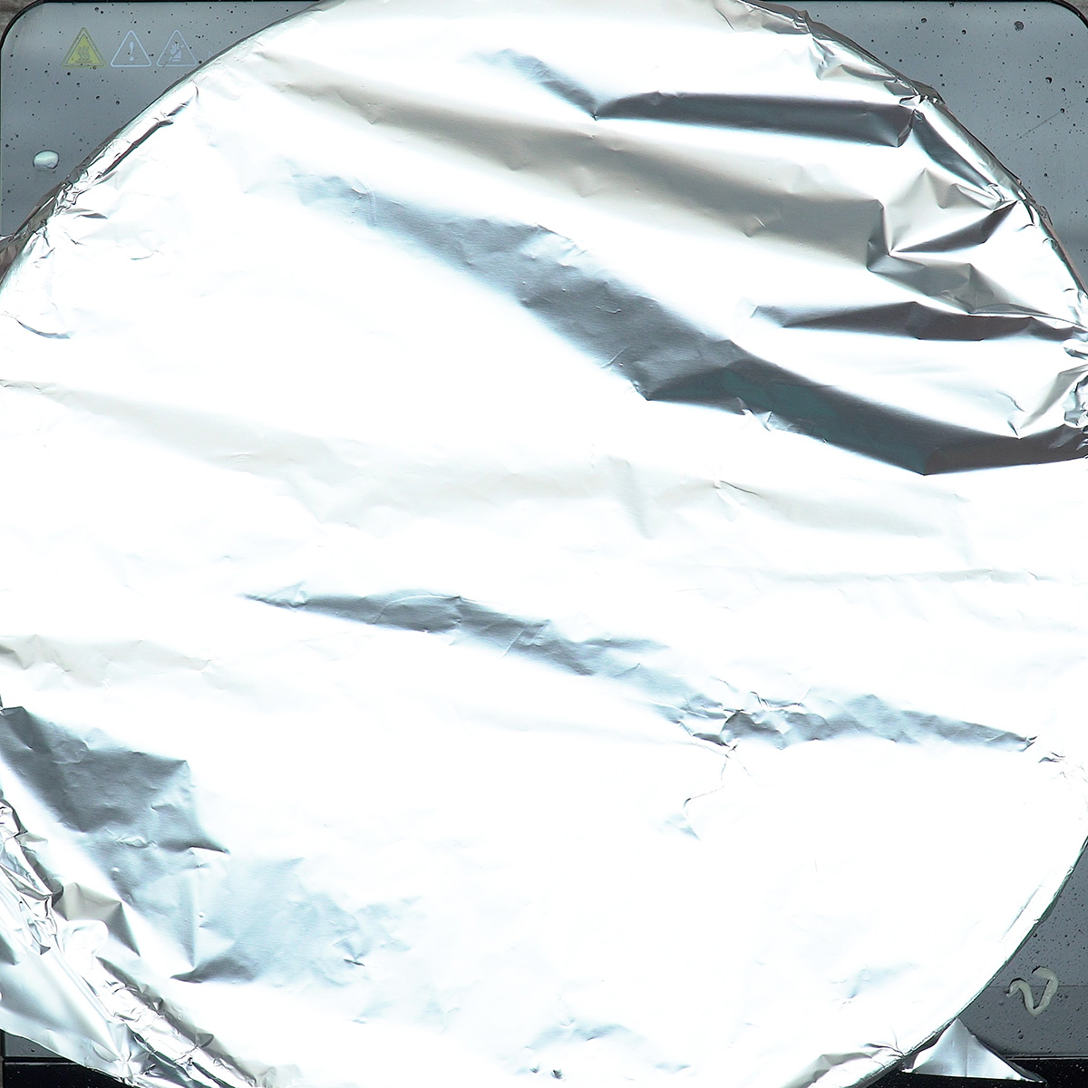 Lasanha de frigideira cozinhando lentamente coberta com papel-alumínio.