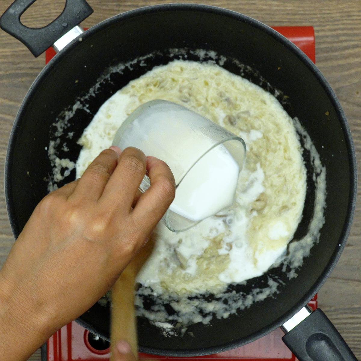 Molho branco cremoso sendo preparado com leite e farinha.