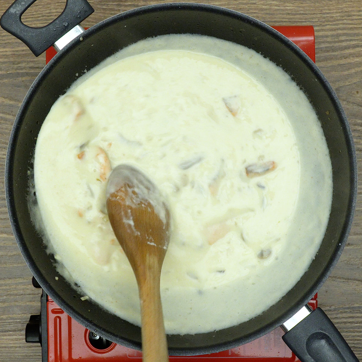 Pedaços de salmão envolvidos em molho cremoso com cogumelos.