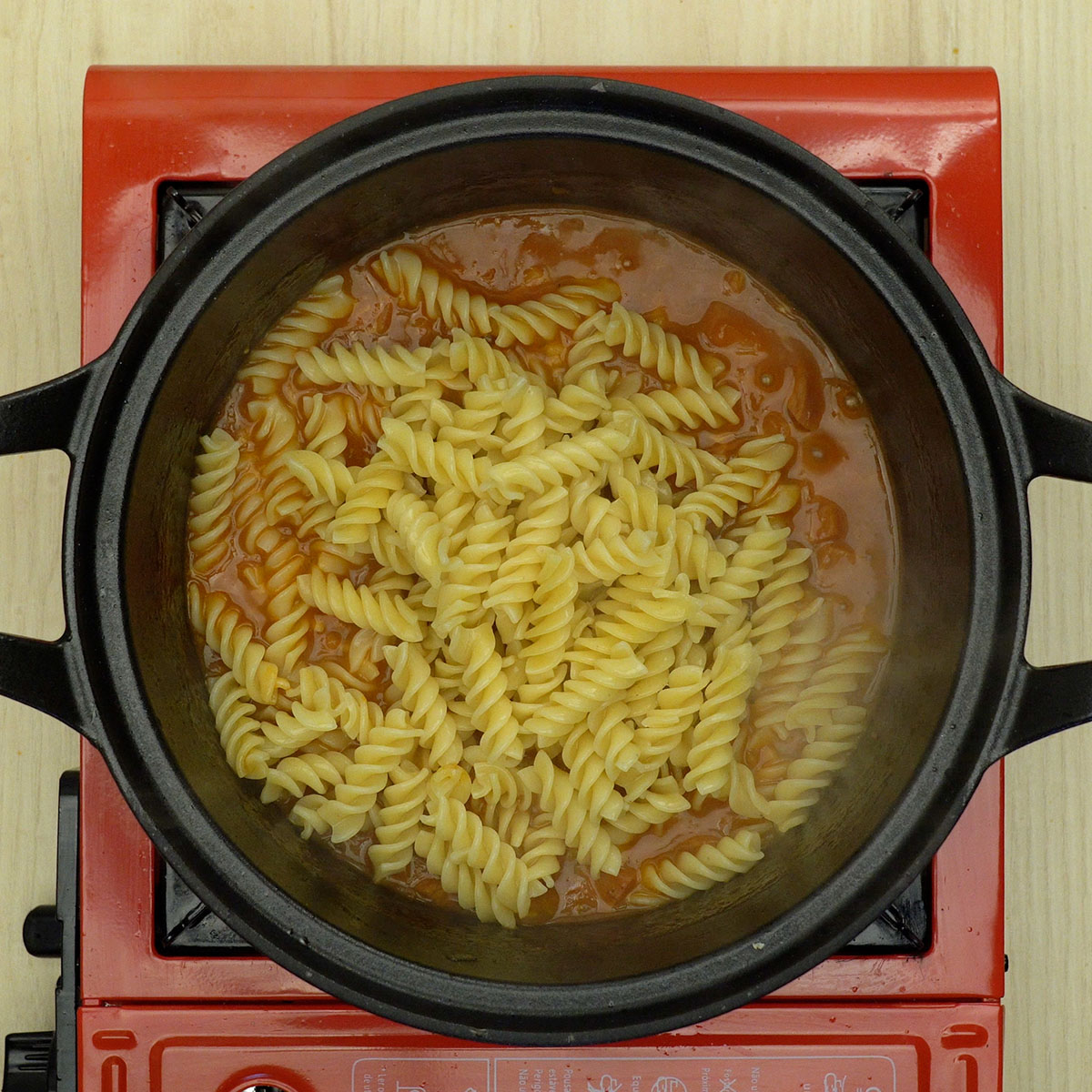 Macarrão parafuso misturado ao molho de tomate com calabresa.