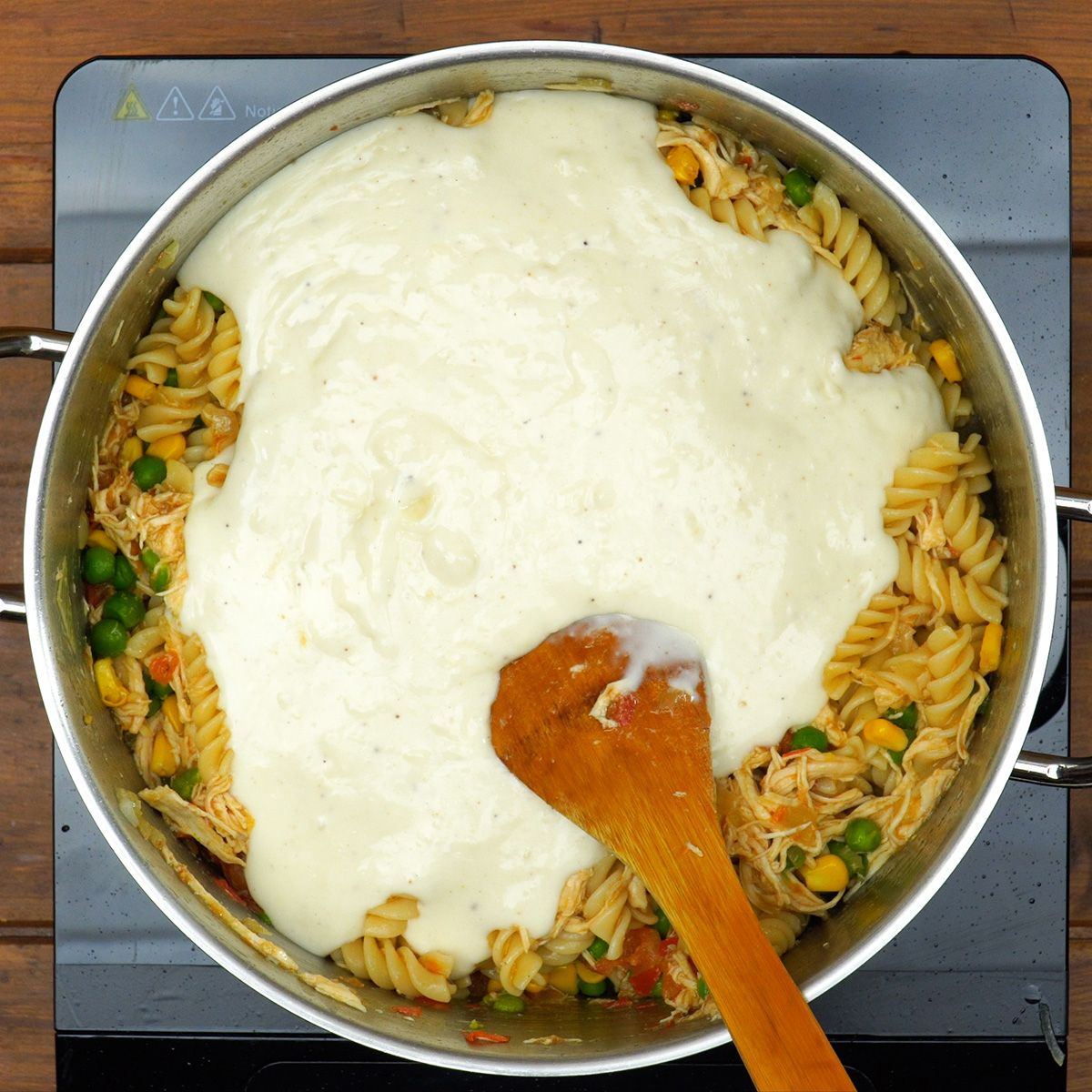 Massa misturada ao molho branco e recheio de frango.