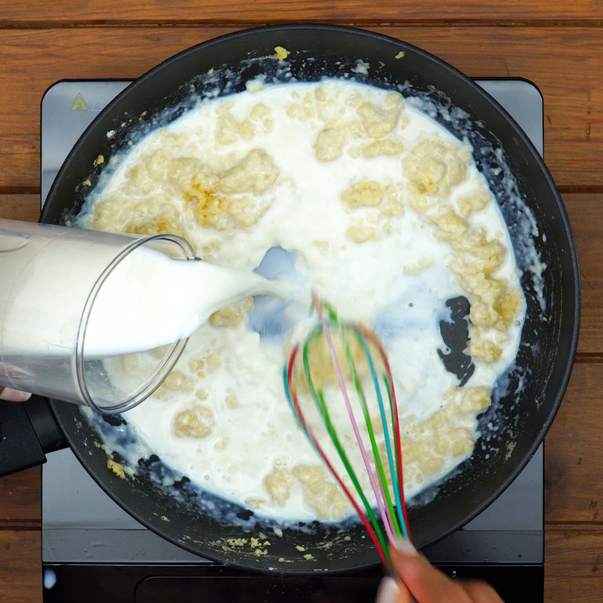 Molho branco cremoso sendo preparado para macarrão gratinado com frango.