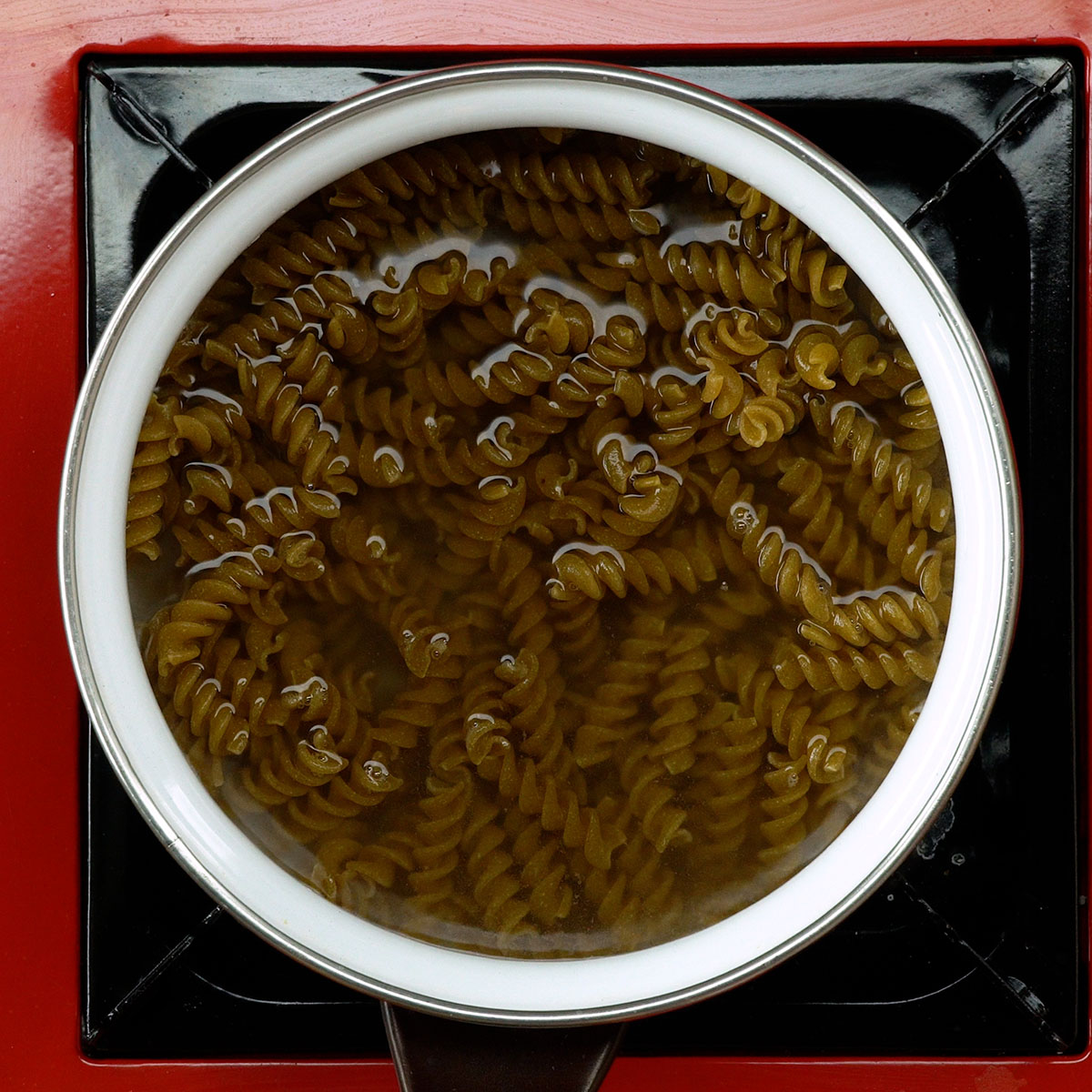Macarrão integral cozinhando em água fervente.