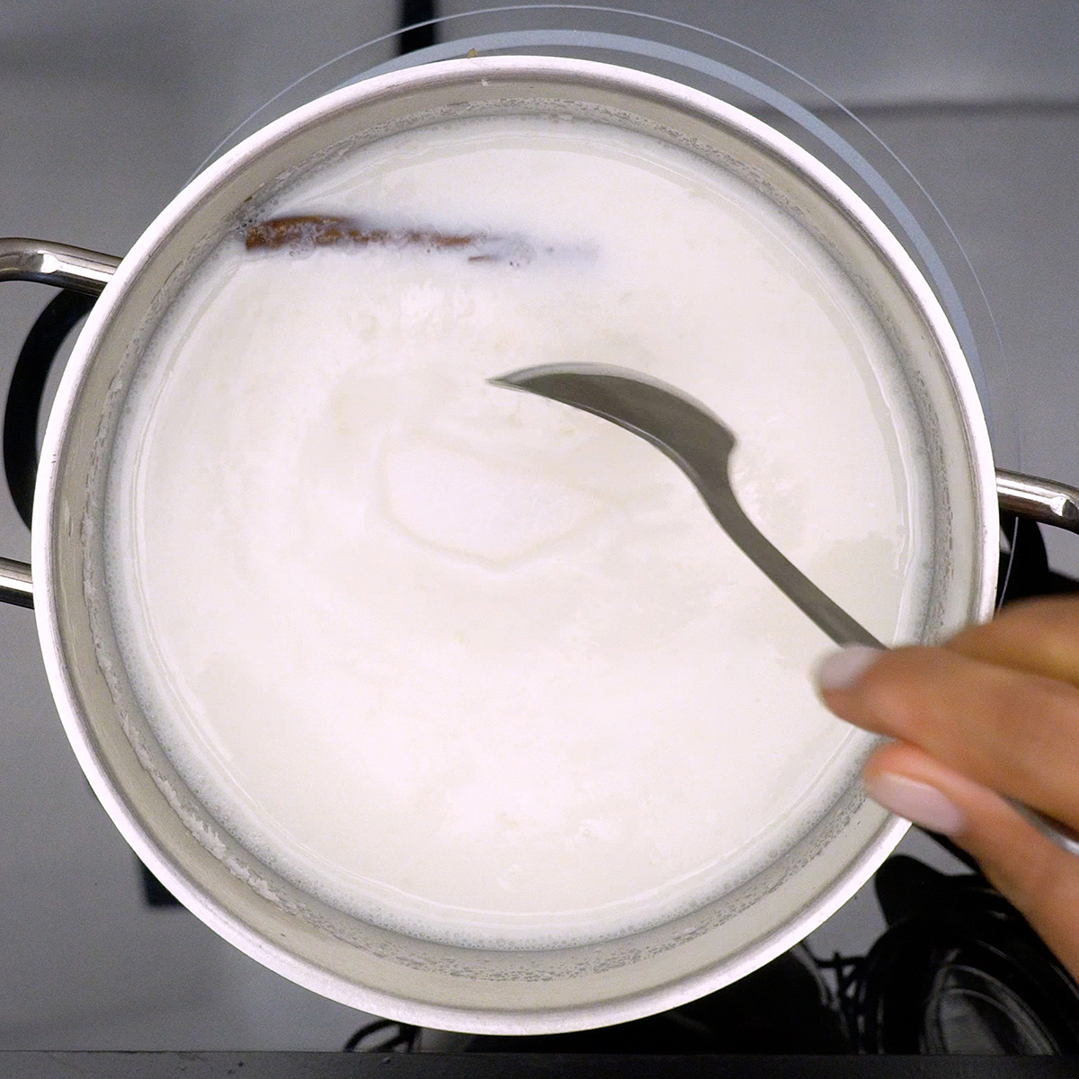 Açúcar sendo misturado ao mingau de tapioca durante o cozimento.